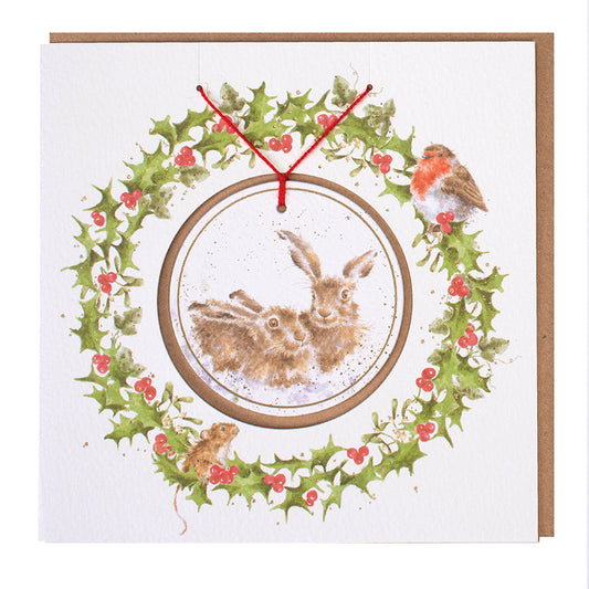 Wrendale Designs Christmas card with foiled, detachable decoration featuring Hannah Dale's artwork of two Hares snuggled together in the snow and titled <i>Warm Christmas Wished</i>
