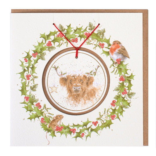 Wrendale Designs Christmas card with foiled, detachable decoration featuring Hannah Dale's artwork of a Highland Cow festively adorned with Holly & a Star and titled <i>Highland Star</i>