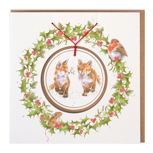 Wrendale Designs Christmas card with foiled, detachable decoration featuring Hannah Dale's artwork of two Fox cubs carrying sprigs of Mistletoe & Holly and titled <i>Glad Tidings we bring</i>