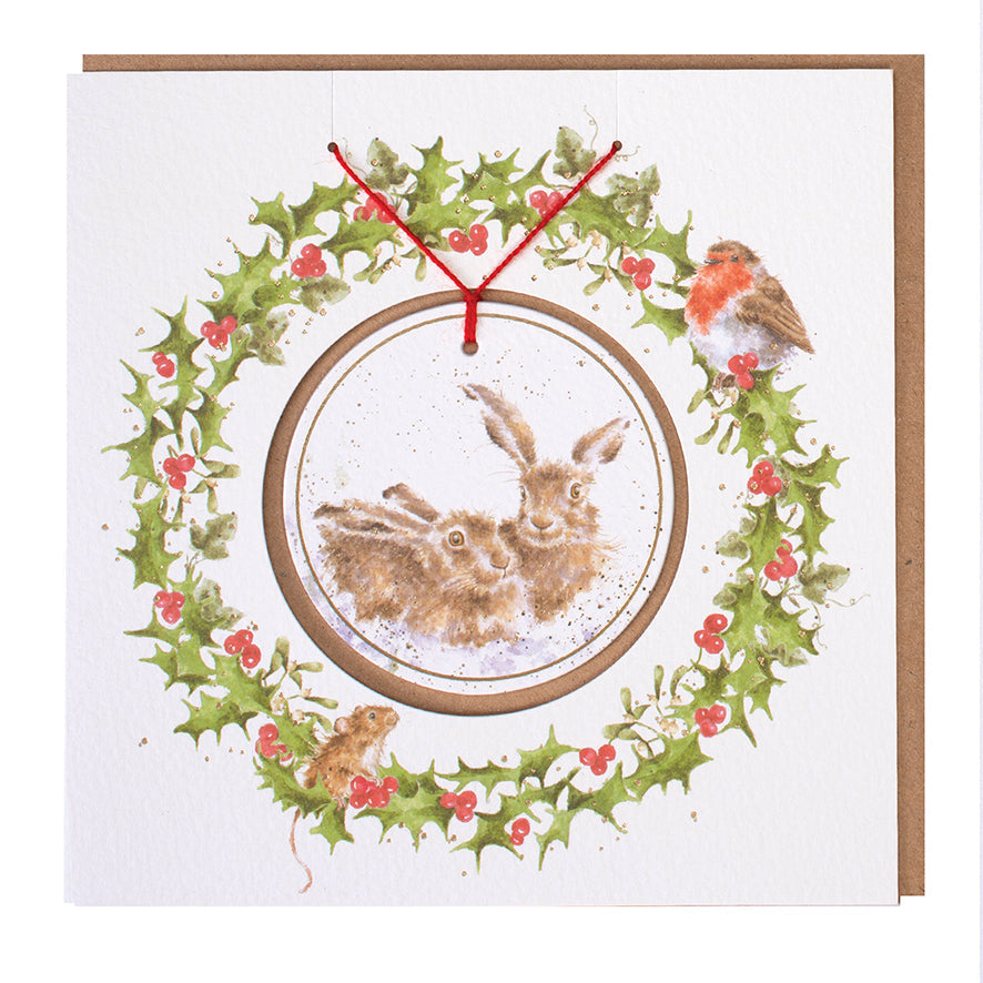 Wrendale Designs Christmas card with foiled, detachable decoration featuring Hannah Dale's artwork of two Hares snuggled together in the snow and titled <i>Warm Christmas Wished</i>