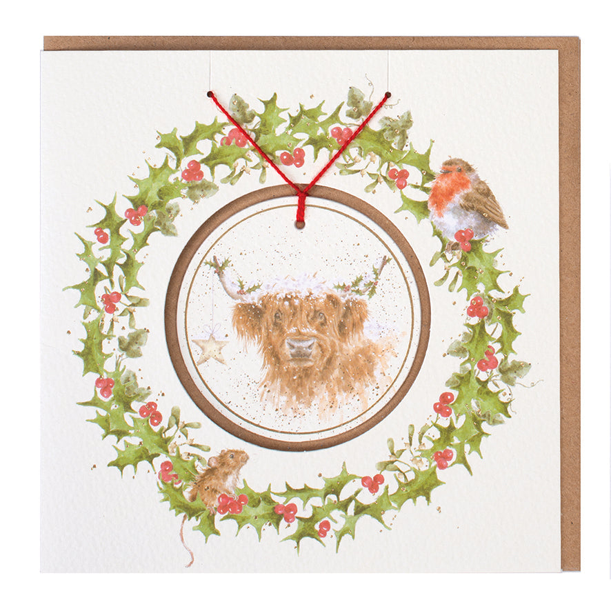 Wrendale Designs Christmas card with foiled, detachable decoration featuring Hannah Dale's artwork of a Highland Cow festively adorned with Holly & a Star and titled <i>Highland Star</i>